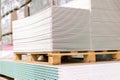 Pallet with Drywall sheets plasterboard in the building warehouse store. Stacking of white gypsum panels, drywall or plasterboard Royalty Free Stock Photo