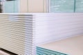 Pallet with Drywall sheets plasterboard in the building warehouse store. Stacking of white gypsum panels, drywall or plasterboard Royalty Free Stock Photo