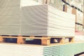 Pallet with Drywall sheets plasterboard in the building warehouse store. Stacking of white gypsum panels, drywall or plasterboard Royalty Free Stock Photo