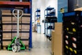 A pallet stacked with boxes ready to be shipped out. A pallet truck is sitting under the pallet to ready move it. Warehouse,