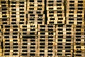Pallets background. Stacks of brown rough wooden pallets at warehouse in industrial yard. Cargo and shipping concept Royalty Free Stock Photo