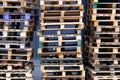 Pallets background. Stacks of colorful rough wooden pallets at warehouse in industrial yard. Cargo and shipping concept Royalty Free Stock Photo