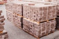 pallets of freshly produced red bricks in a construction warehouse on the street. Concept of repair and building