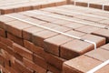 packages of freshly produced red bricks in a construction warehouse on the street. Concept of repair and building