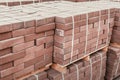 packages of freshly produced red bricks in a construction warehouse on the street. Concept of repair and building