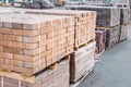 packages of freshly produced red bricks in a construction warehouse on the street. Concept of repair and building