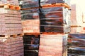 Pallets with red bricks outdoors. Building materials wholesale. pallets and packages of freshly produced red bricks in a