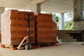 Pallets with red bricks at the stage of construction in a new building