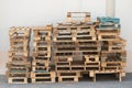 Pallets stacked on top of each other on the ground and against a white wall
