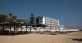 Palm Beach with beach umbrellas and tourists and abandoned hotels atghost town, Famagusta, Northern Cyprus