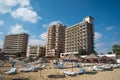 Palm Beach with beach umbrellas and tourists and abandoned hotels atghost town, Famagusta, Northern Cyprus