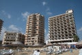 Palm Beach with beach umbrellas and tourists and abandoned hotels atghost town, Famagusta, Northern Cyprus