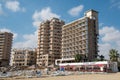 Palm Beach with beach umbrellas and tourists and abandoned hotels atghost town, Famagusta, Northern Cyprus