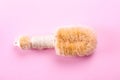 Palm fiber dry body brush on pale pink background