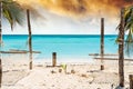 Palm and hammock on Zanzibar beach with blue sky and ocean on the background Royalty Free Stock Photo