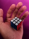 the palm of the hand holding a rubik box with a unique color combination