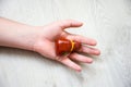 In palm of hand lying on wooden floor, is anatomical model of liver or hepar. Concept photo depicting liver illness such as cancer