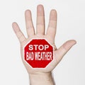 On the palm of the hand there is a stop sign with the inscription - STOP BAD WEATHER Royalty Free Stock Photo