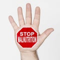 On the palm of the hand there is a stop sign with the inscription - STOP MALNUTRITION