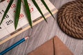 Palm leaf, calendar, pencil and envelope from old paper on a wooden table texture Royalty Free Stock Photo