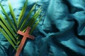 Palm leaves with wooden crucifix cross flat lay. Palm sunday celebration background. Royalty Free Stock Photo