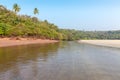 Palm tree, jungle and river on rocky and sandy coast Royalty Free Stock Photo