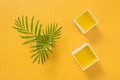 Palm leaves and decorative boxes on yellow background