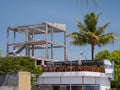 Palm tree rustles next to a tourist apartment building under construction. Royalty Free Stock Photo