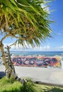 Palm tree and seaside rampart decorated with graffiti on the Sunset beach in Chatan City in the American Village of Okinawa island