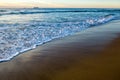 Wave of the sea and sand at sunset boats on the horizon