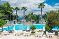 Palm trees, beach sunbeds and umbrellas near the pool by the sea in sunny day Royalty Free Stock Photo