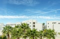 Palm trees infrount of a hotel foreside with blue sky and clods over it Royalty Free Stock Photo