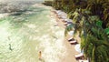 Palm trees over a tropical island with an exotic white beach with bathing people on a Sunny day with blue sky. 3D Royalty Free Stock Photo