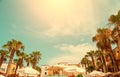 Palm trees sky sun and roof of european hotel with umbrellas in nature frame , bright Sunny day, the concept of a resort