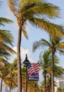Palm trees and the US flag on Fort Lauderdale's beach on a windy day, Florida, USA Royalty Free Stock Photo