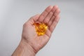 In the palm of the yellow translucent medicine capsules