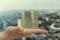 In the palm of your hand is a city block of skyscrapers. Concept: construction of new housing in the city, modern buildings,cities