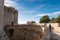 Female tourist walking on the defending walls of the Bellver castle with a blue sky background, Mallorca, Spain