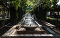 Palma de Mallorca, Mallorca - Spain - Water fountain drops and sunny counter light in a city garden with a row of