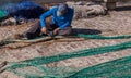 Palma de Mallorca, Spain 03-24-2021: Fisherman repairing fish nets