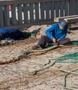 Palma de Mallorca, Spain 03-24-2021: Fisherman repairing fish nets