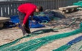 Palma de Mallorca, Spain 03-24-2021: Fisherman repairing fish nets