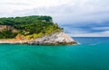 Palmaria island with green trees, cliffs, rocks and blue turquoise water of Ligurian sea with dramatic sky background