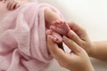 The palms of the father, the mother are holding the foot of the newborn baby in a pink blanket. Royalty Free Stock Photo