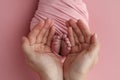 The palms of the father, the mother are holding the foot of the newborn baby in a pink blanket. Royalty Free Stock Photo