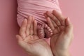 The palms of the father, the mother are holding the foot of the newborn baby in a pink blanket. Royalty Free Stock Photo