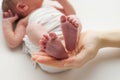 The palms of the father, the mother are holding the foot of the newborn baby in a white blanket. Royalty Free Stock Photo