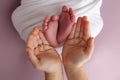 The palms of the father, the mother are holding the foot of the newborn baby in a white blanket, Royalty Free Stock Photo