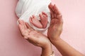 The palms of father, the mother are holding foot of the newborn baby in a white, pink background. Royalty Free Stock Photo