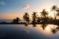 Palms reflections in pool water surface in sunset on tropical Island Royalty Free Stock Photo